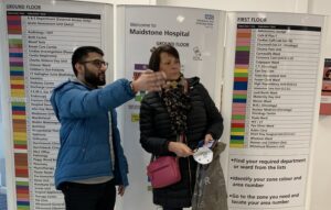 A male learner directing a member of the public to the correct area of the hospital, as part of a work placement